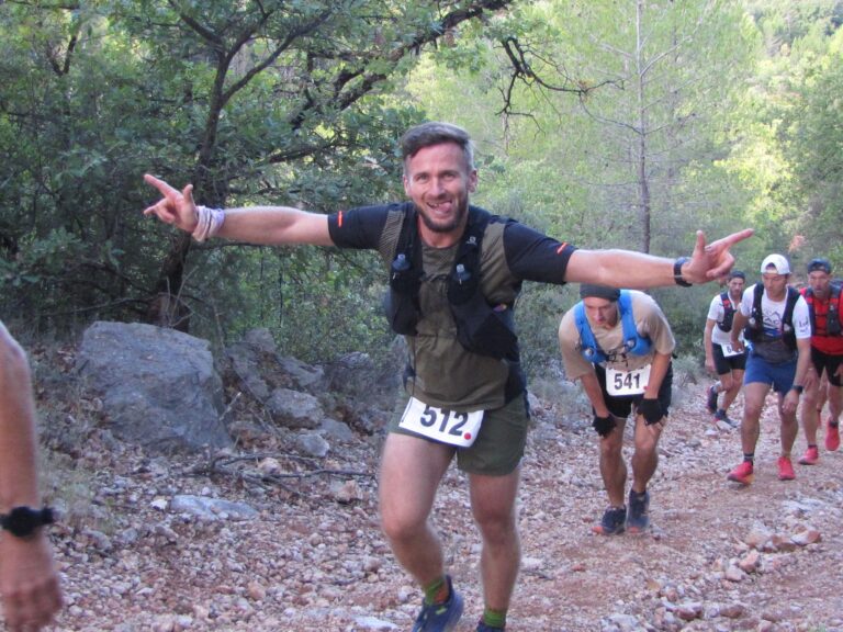 Coureur faisant une grimace et les bras levés.